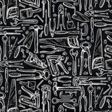 Pattern of black and white tools on a black background