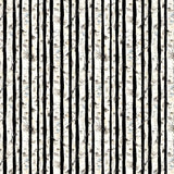 Pattern of black and white vertical stripes with tree branches on a fabric background.